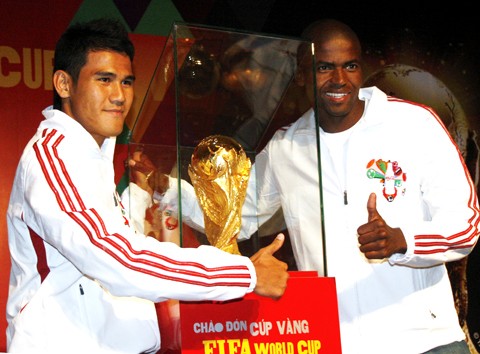 Dong Tam Long An Club’s striker Phan Thanh Binh (L) and Binh Duong Club’s forward Philani, brand ambassadors of Coca-Cola Vietnam, pose for pictures with the FIFA World Cup trophy at Monday’s press briefing at Caravelle Hotel (Photo: VNExpress)